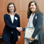 Elizabeth Sadowski, MD, accepts the 2024 Excellence in Mentorship Award from Cherri Hobgood, MD.