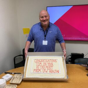 Thomas McKinlay poses with a cake during his retirement party.