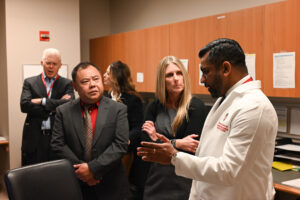 Five people standing in a room, discussing something together.