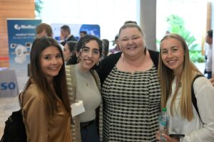 A group of four women pose for a photo at the symposium.