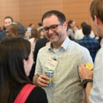 A man in the crowd smiles during conversation at the symposium.